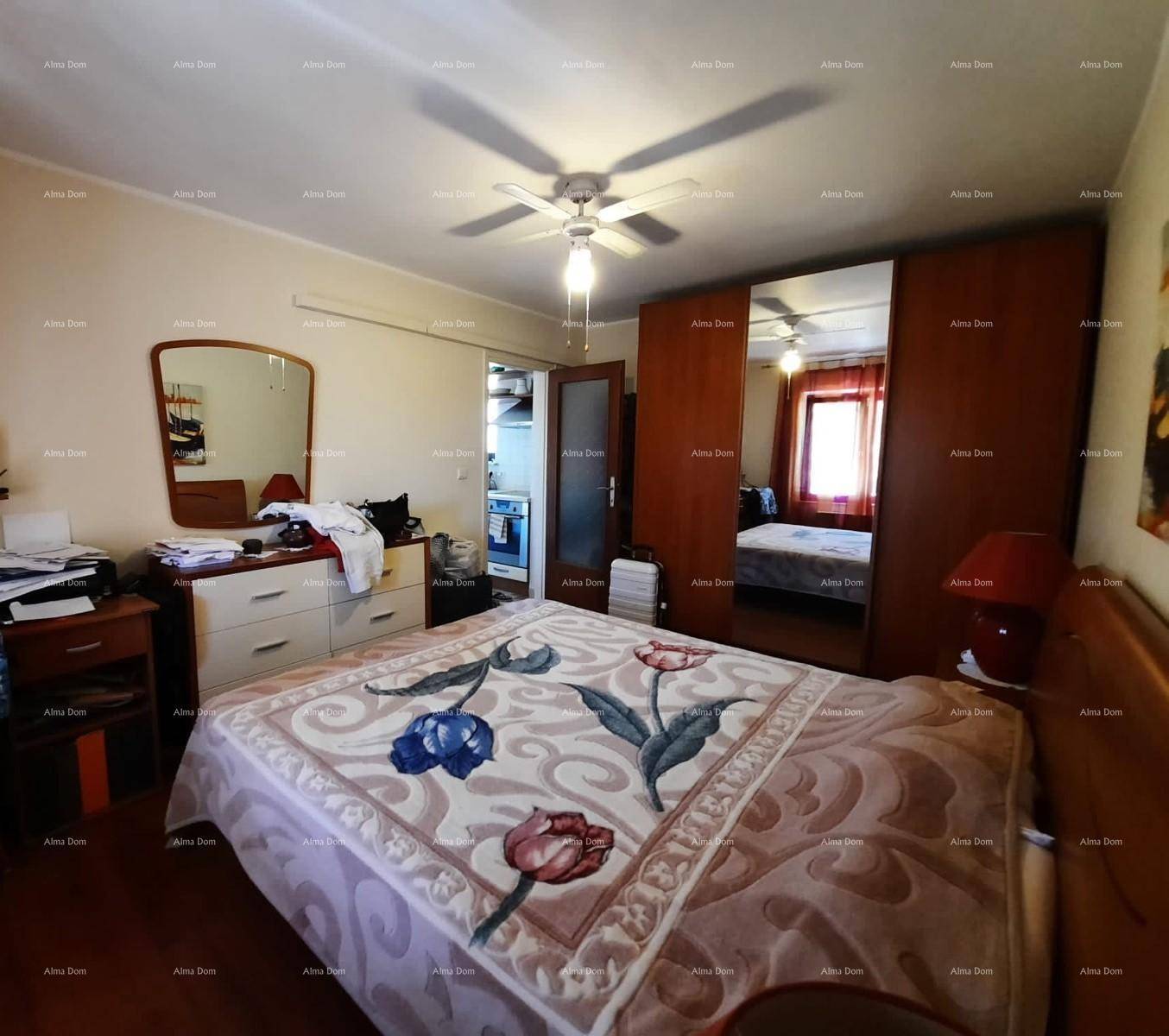 Gemütliches Schlafzimmer mit großem Bett, Deckenventilator und Spiegelschrank.