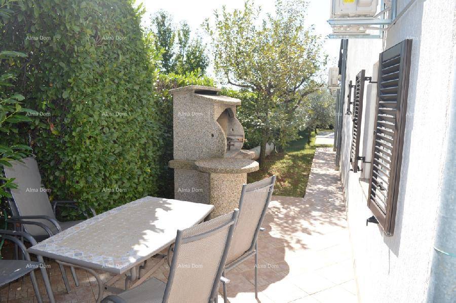 Außenbereich mit gemauertem Grill und Esstisch, ideal für Mahlzeiten im Freien an einem sonnigen Tag.