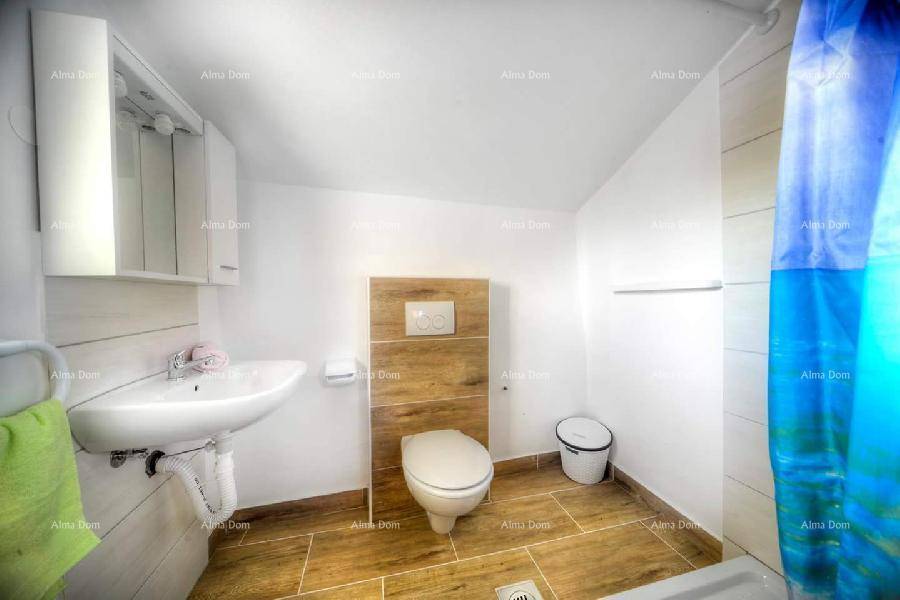Modernes Badezimmer mit Holzbodenfliesen, wandhängendem WC und Duschbereich.