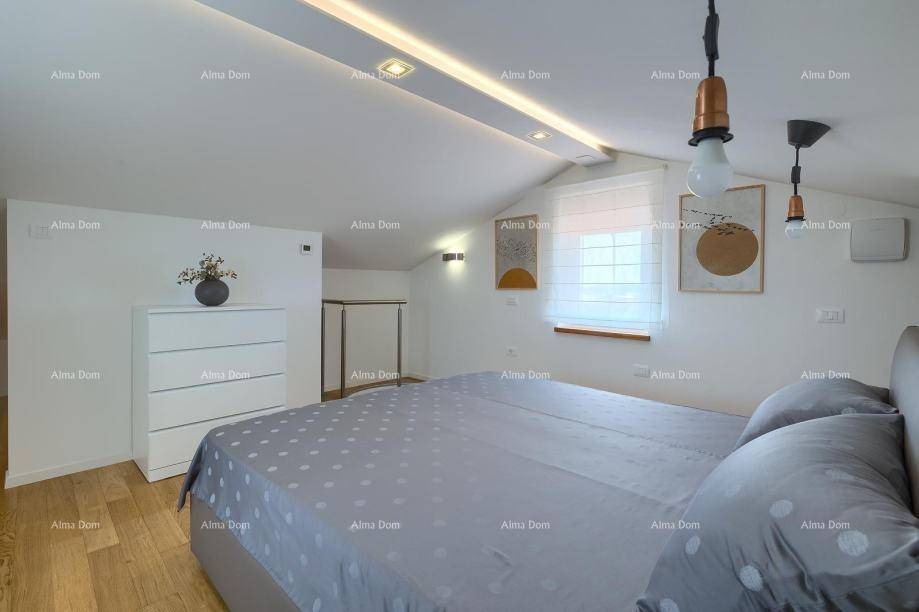 Schlafzimmer im Dachgeschoss mit Doppelbett, Kommode und Holzboden, hell und modern.