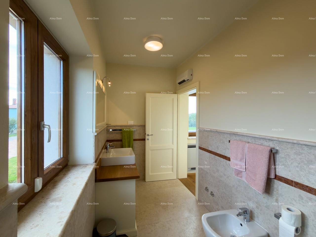 Helles Badezimmer mit Fenster, Einzelwaschbecken, Bidet und Blick ins Grüne.