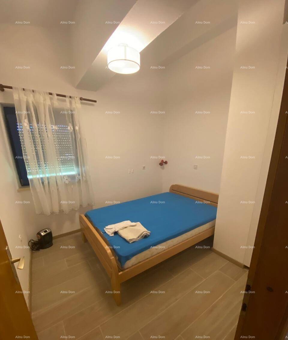 Helles Schlafzimmer mit Holzbett und Fenster, das durch einen Rollladen verdunkelt werden kann.