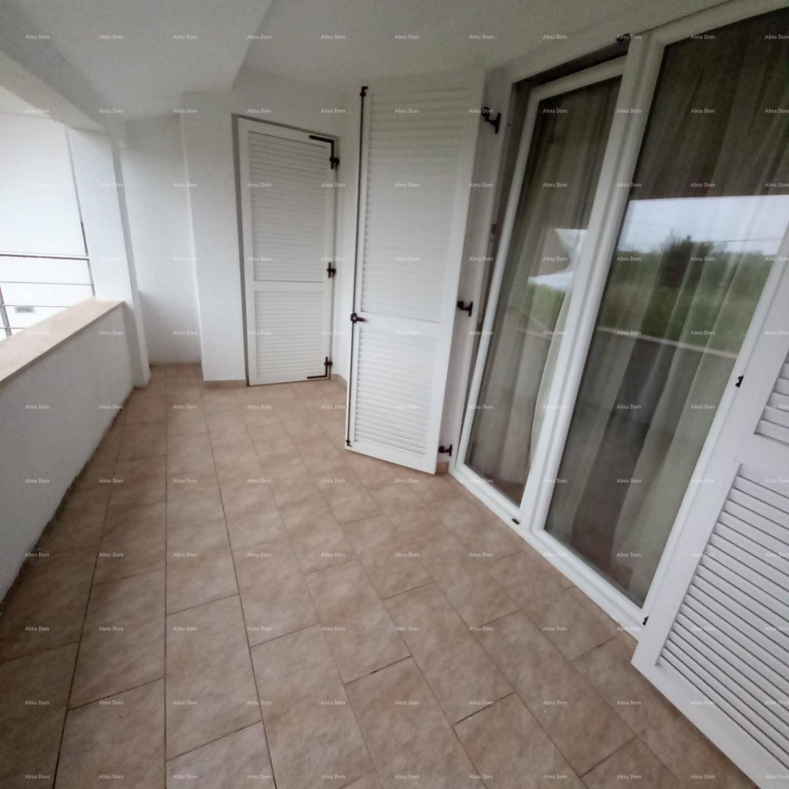 Heller Balkon mit Fliesenboden und großen Fenstern, die den Zugang zum Innenbereich ermöglichen.