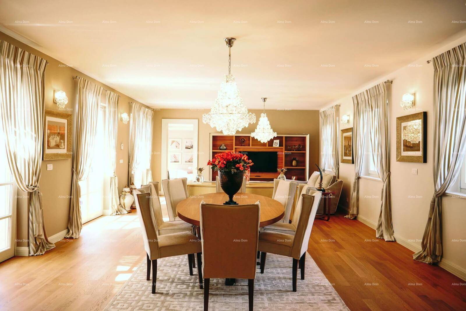 Geräumiger Wohn- und Essbereich mit Holzboden, eleganten Kronleuchtern und großen Fenstern.