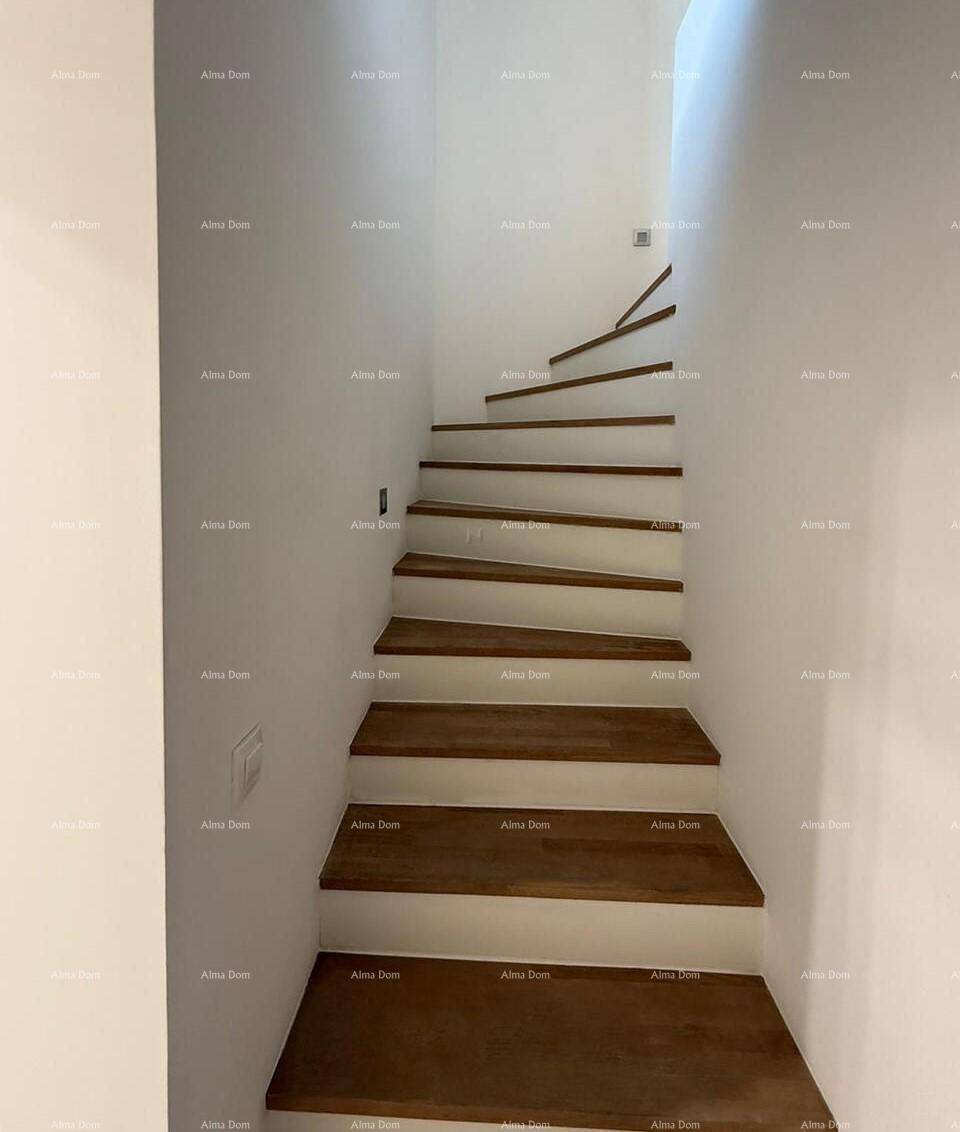 Elegante Holztreppe mit minimalistischem Design und weiß gestrichenen Wänden, die nach oben führt.
