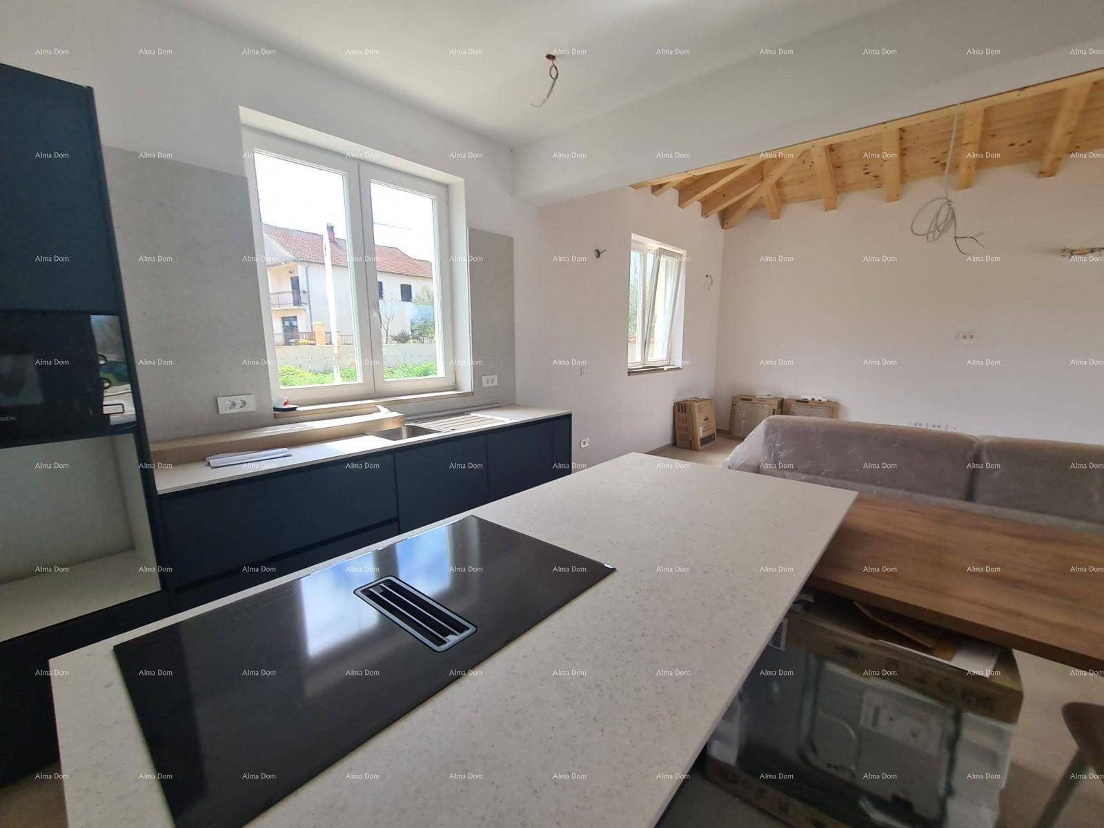 Moderne Küche im Bau mit Kücheninsel, Induktionskochfeld und Blick ins Grüne.