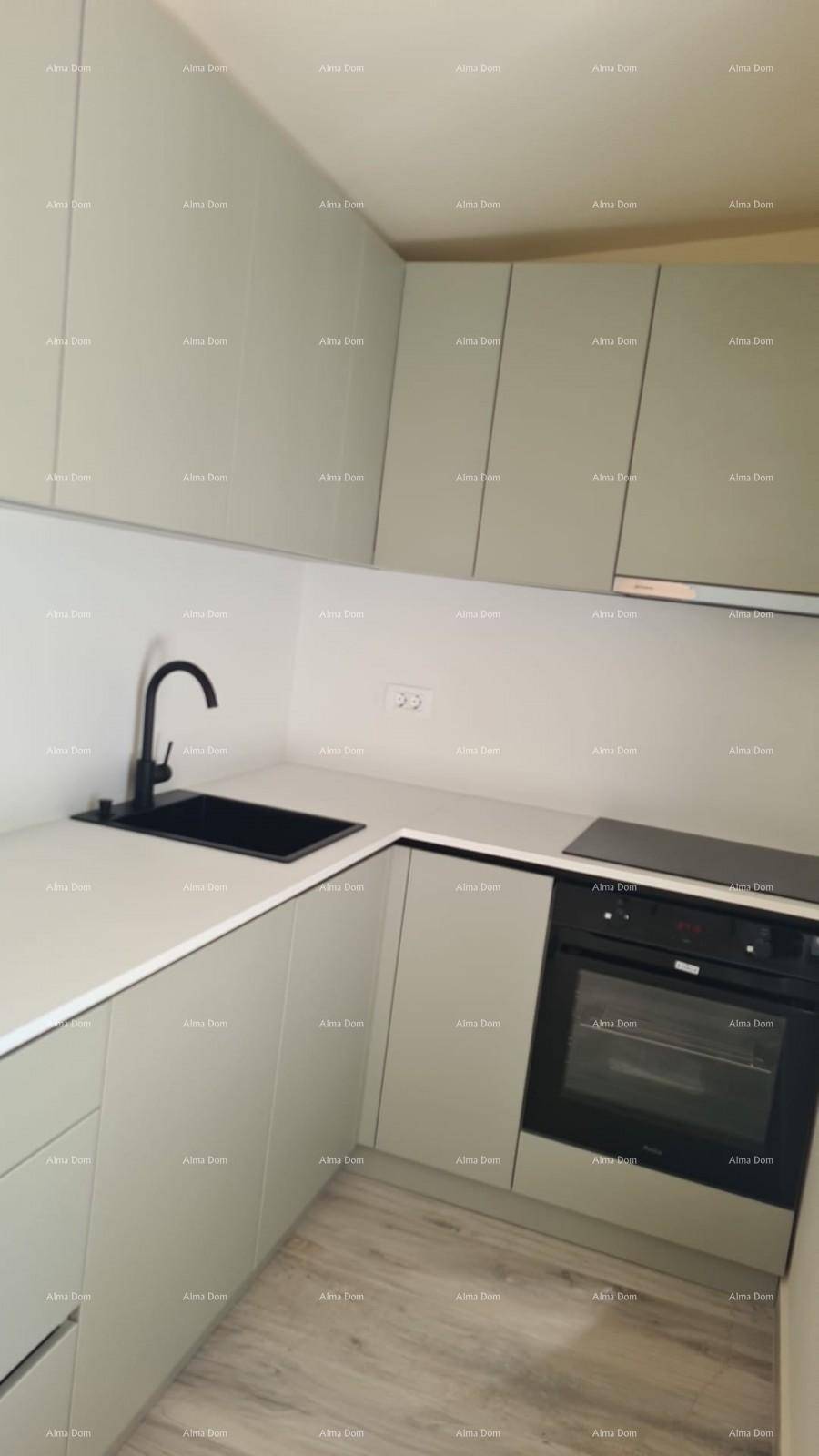 Moderne Einbauküche mit hellgrauen Schränken, schwarzer Spüle und integriertem Backofen.