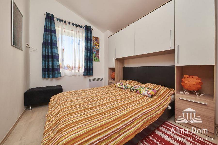 Gemütliches Schlafzimmer mit Doppelbett, integrierten Schränken und Fenster.