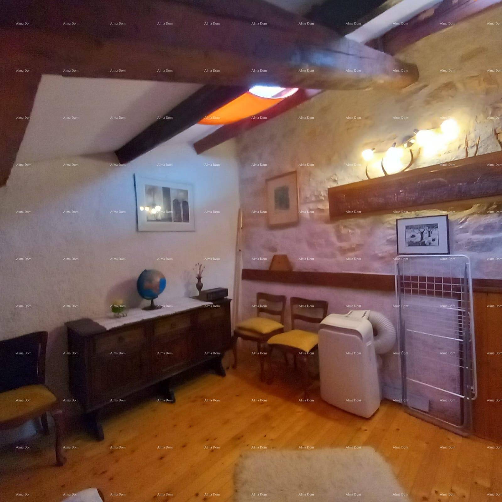 Schlafzimmer mit Holzboden, Steinwand und einem mobilen Klimagerät unter Holzbalken.