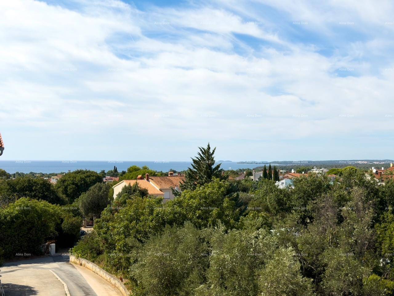 Panoramablick auf das Meer und die Küstenlandschaft mit üppiger Vegetation und Häusern.