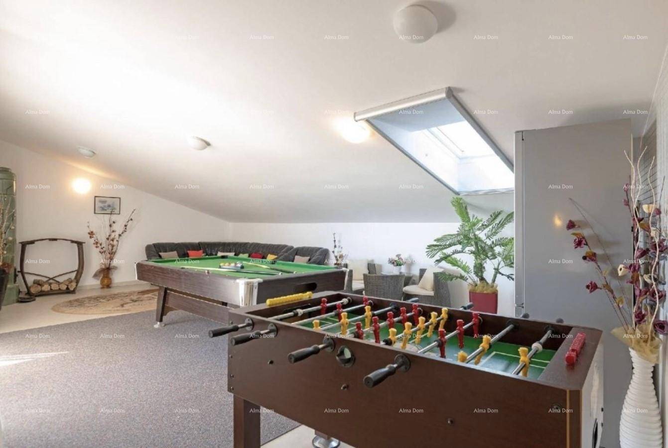 Spielzimmer im Dachgeschoss mit Billardtisch, Kicker und Dachfenster.