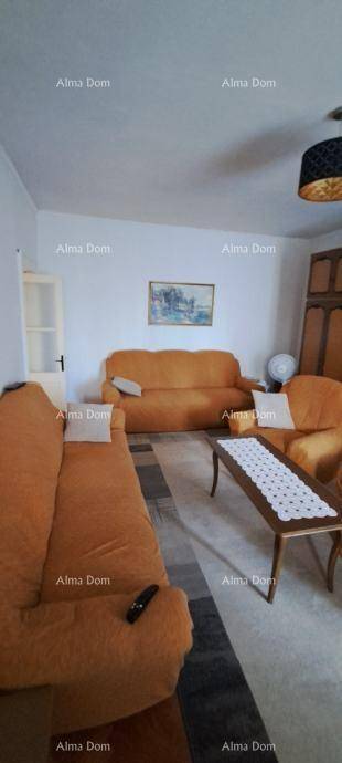 Gemütliches Wohnzimmer mit beigen Sofas, Holzboden und einem traditionellen Schrank.