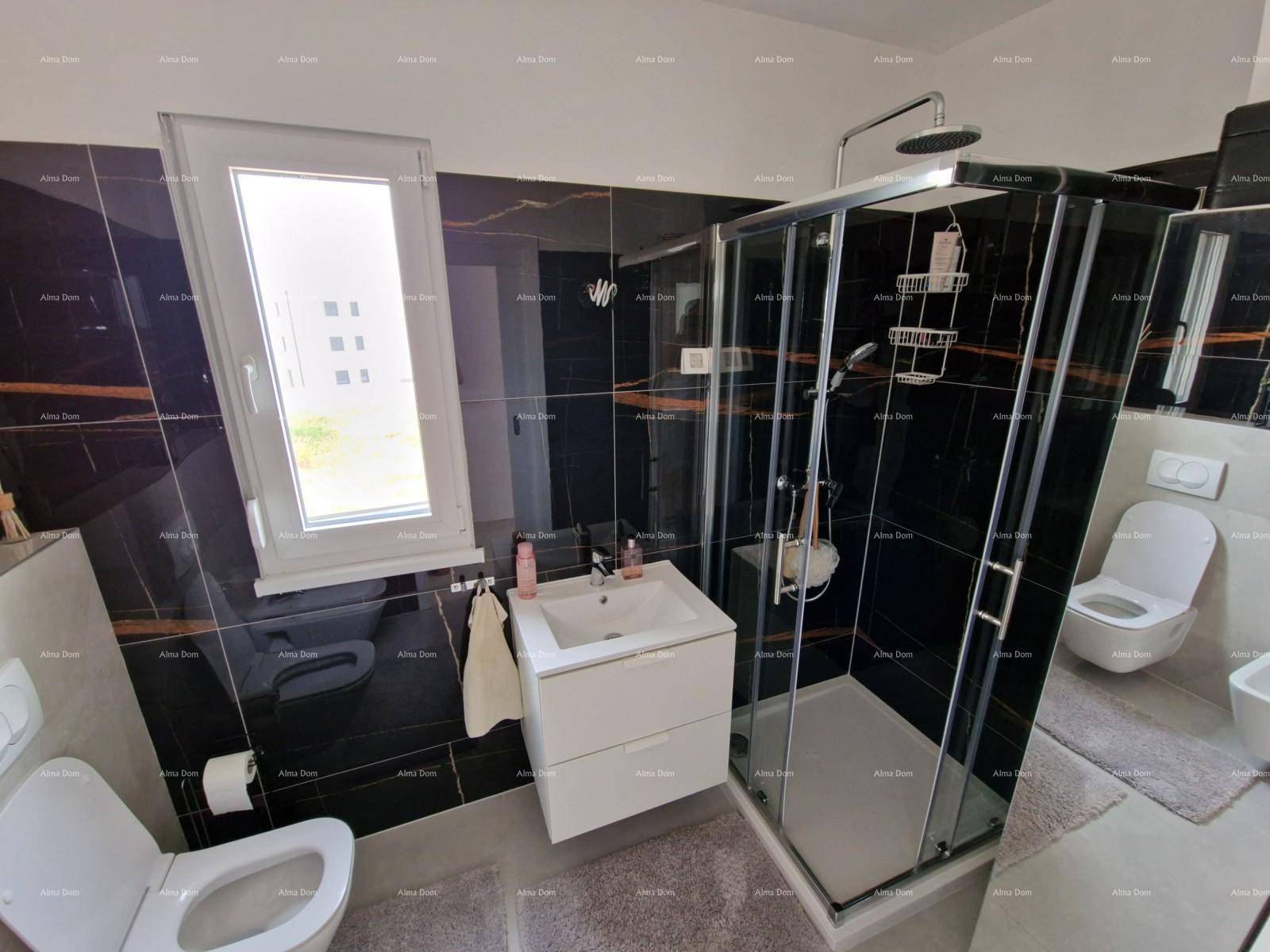 Modernes Badezimmer mit schwarzen Hochglanzfliesen, Duschkabine und Fenster.