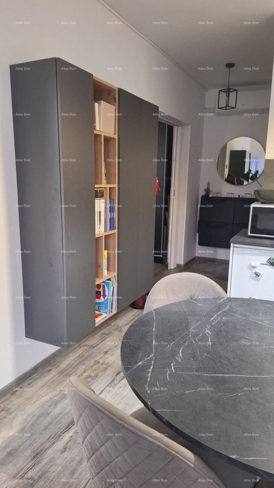Moderne graue Einbauschränke mit integriertem Bücherregal in einem offenen Wohnbereich.