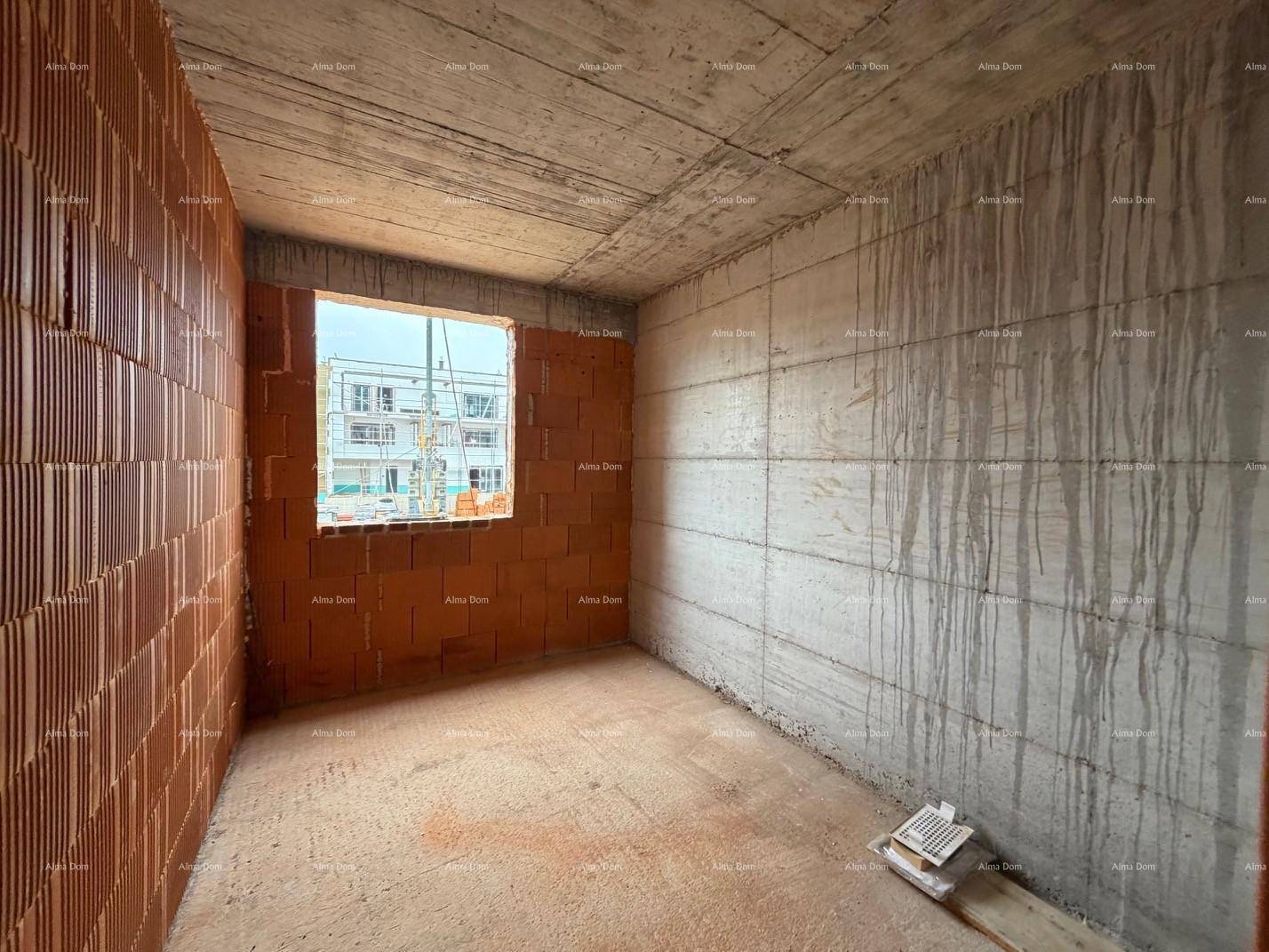 Rohbau-Zimmer mit unverputzten Wänden, Betonboden und einem Fenster mit Blick auf die Baustelle.