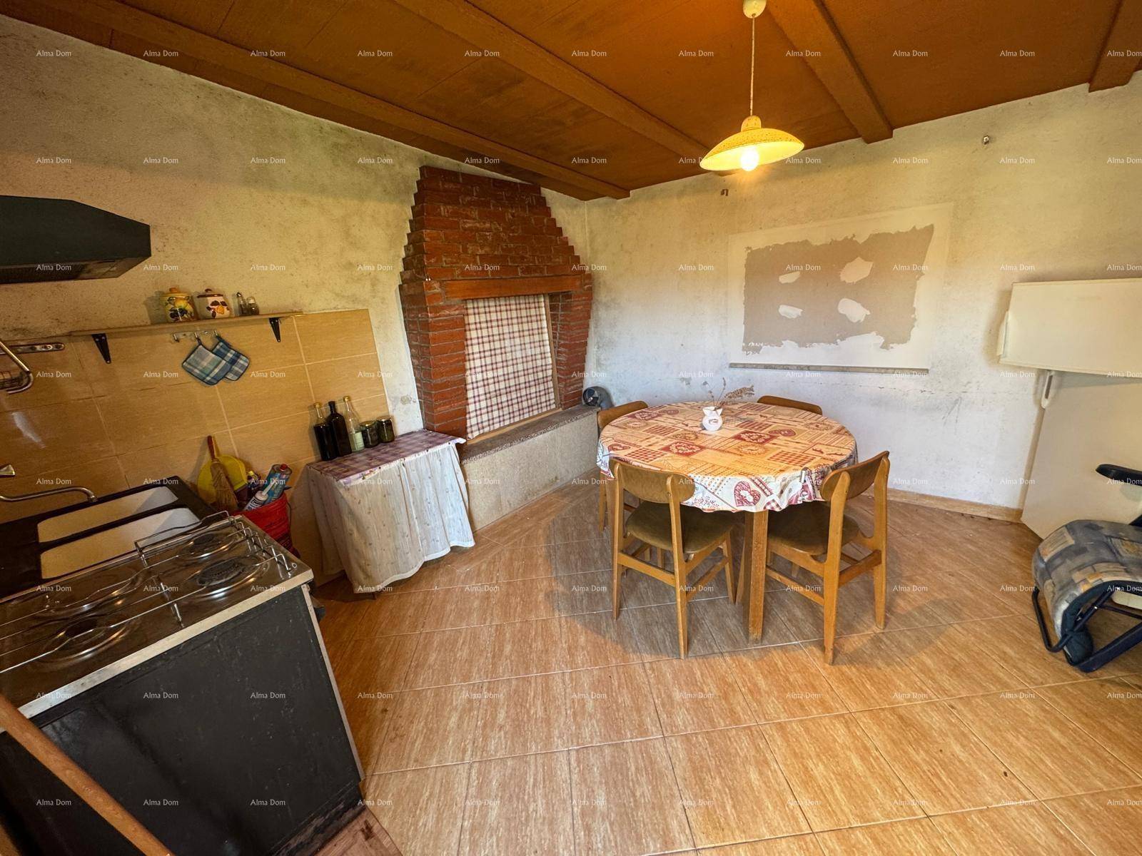 Rustikale Küche mit gemauertem Kamin, Esstisch und Fliesenboden, mit Holzdecke.