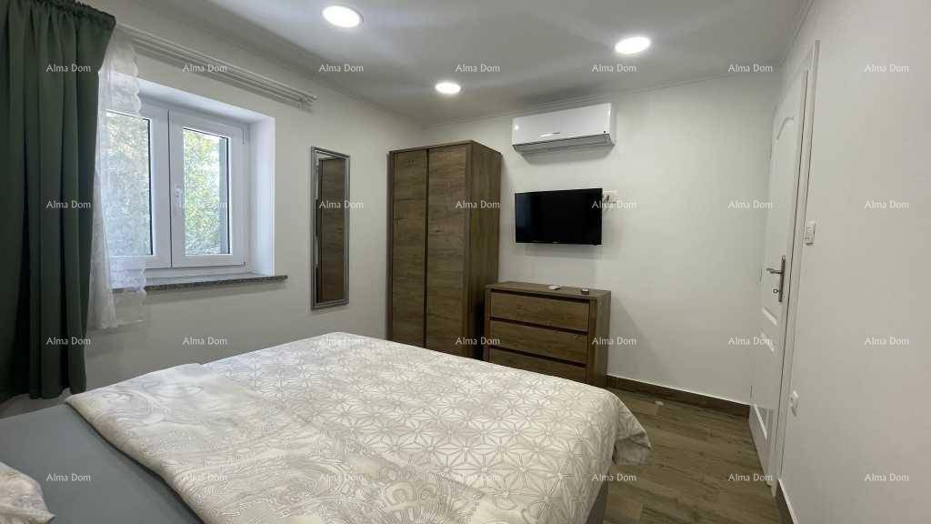 Helles Schlafzimmer mit Doppelbett, großem Kleiderschrank und Flachbildfernseher an der Wand.