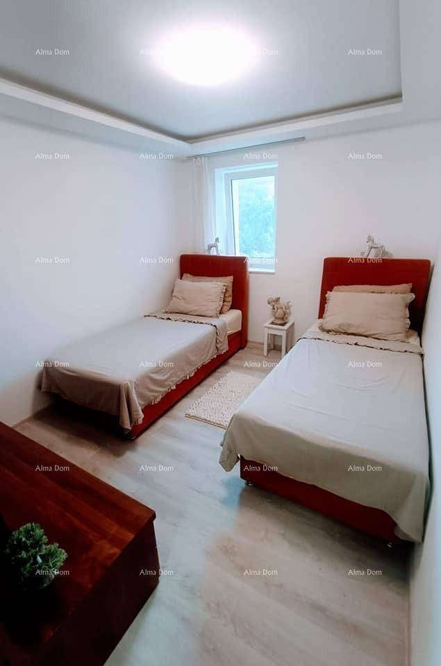 Schlafzimmer mit zwei Einzelbetten, Laminatboden und einem Fenster für natürliches Tageslicht.