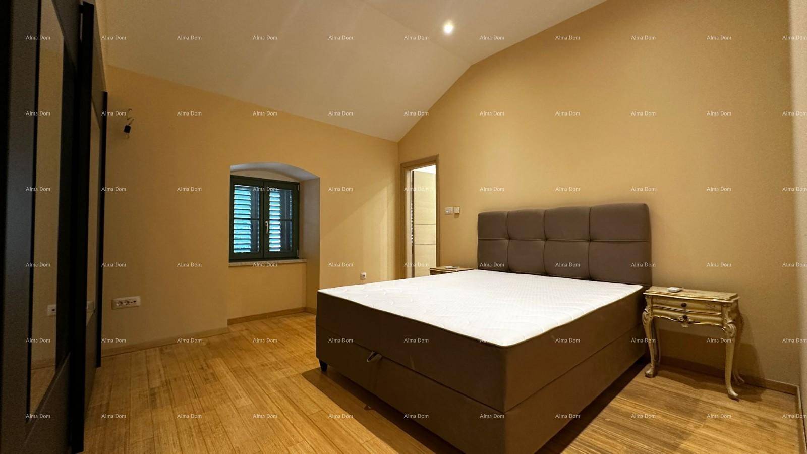 Gemütliches Schlafzimmer mit großem Bett, Holzboden und Fenster mit traditionellen Fensterläden.