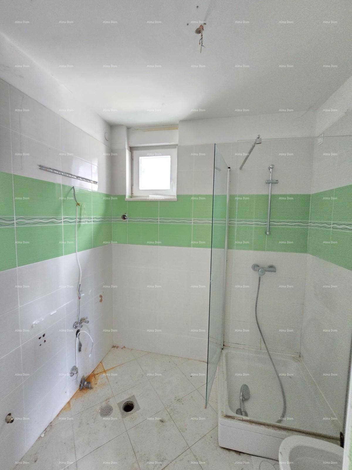 Badezimmer im Renovierungszustand mit grünen und weißen Fliesen und Duschbereich.