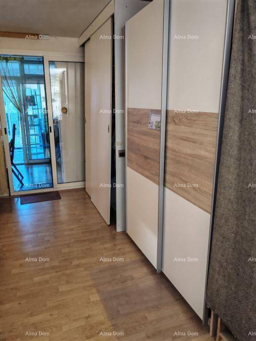Innenraum mit Holzboden, Einbauschränken und einer Glasschiebetür zu einem Außenbereich.