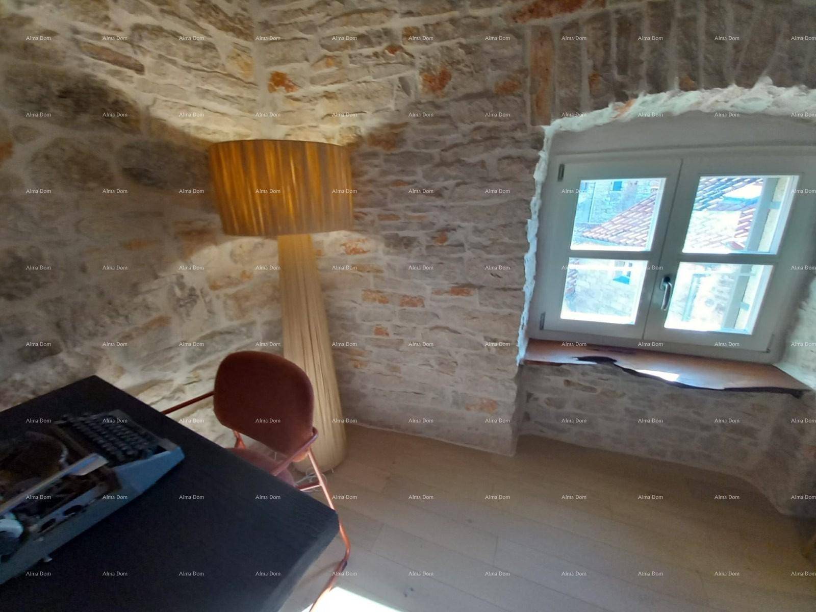 Arbeitsbereich mit Schreibtisch, Steinwänden und einem Fenster mit Blick nach draußen.