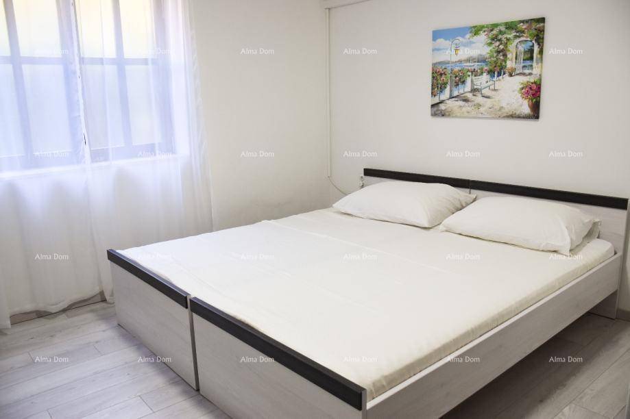 Helles Schlafzimmer mit Doppelbett, weißer Bettwäsche und einem Fenster mit Vorhang.