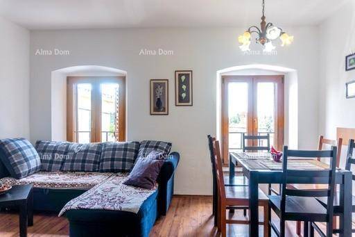 Wohn- und Essbereich mit kariertem Sofa und Esstisch, helle Fenster bieten Ausblick.