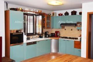 Moderne Einbauküche mit hellblauen Schränken, integrierten Geräten und Fenster.