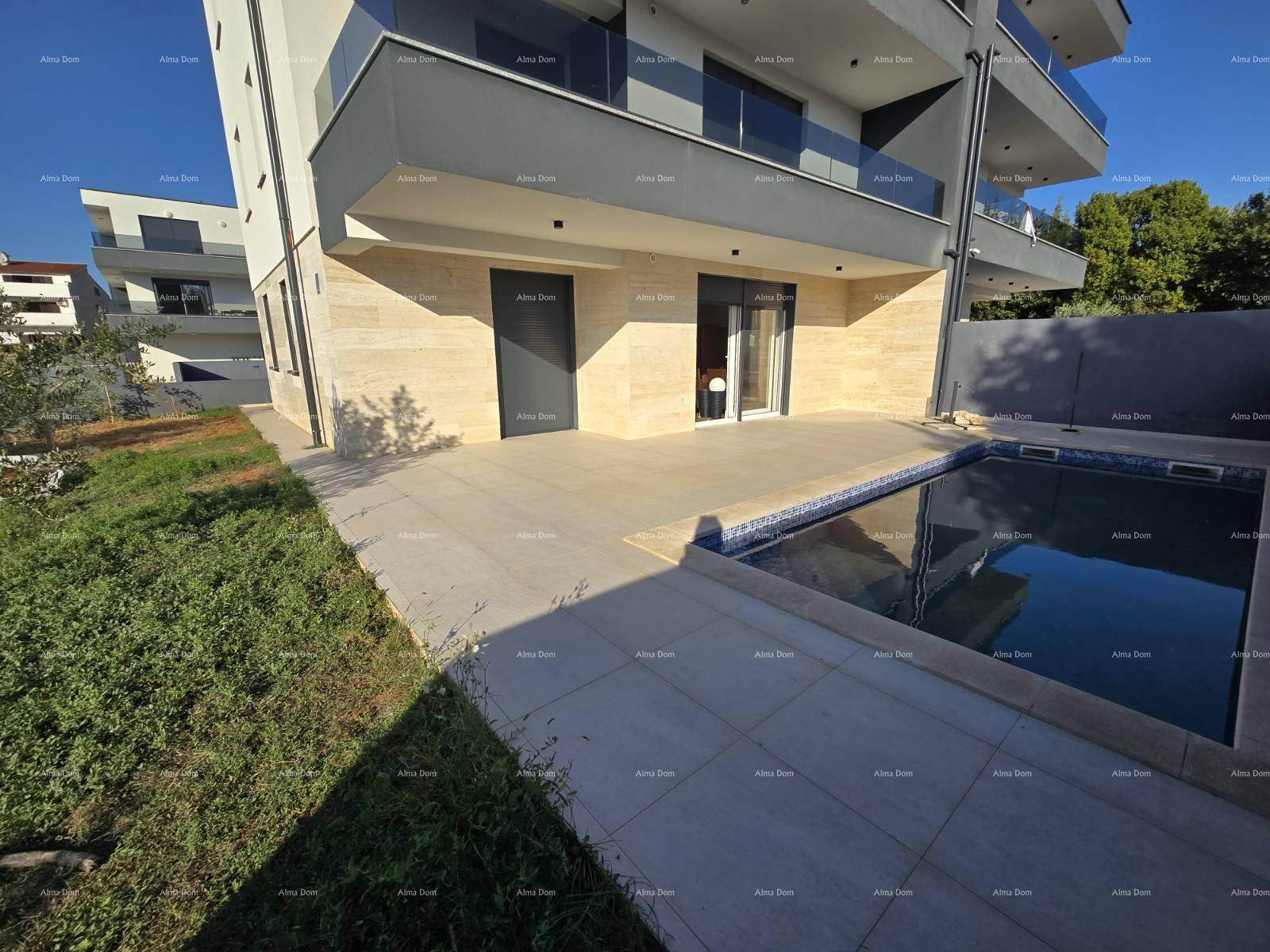 Außenbereich mit Pool, gepflasterter Terrasse und Grünfläche, ideal für Entspannung im Freien.