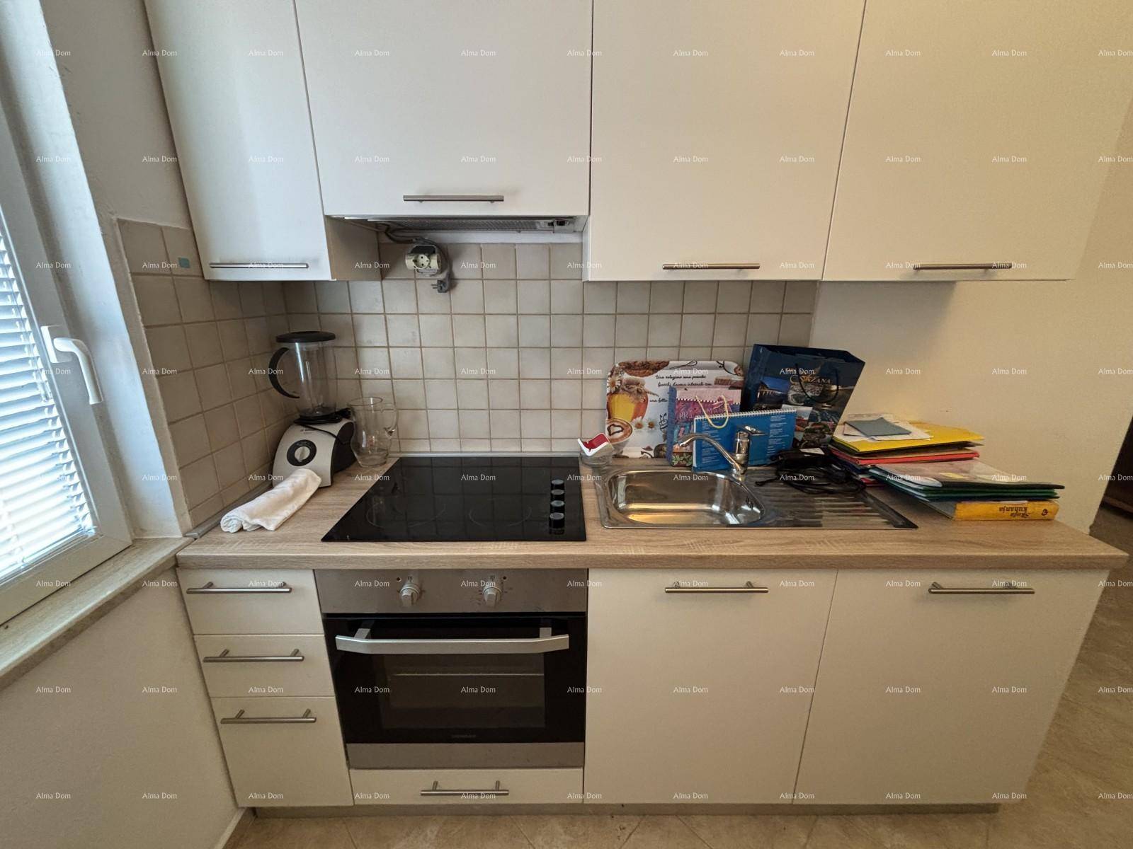 Nahaufnahme einer funktionalen Küchenzeile mit Induktionskochfeld, Backofen und hellen Holz-Arbeitsplatten.