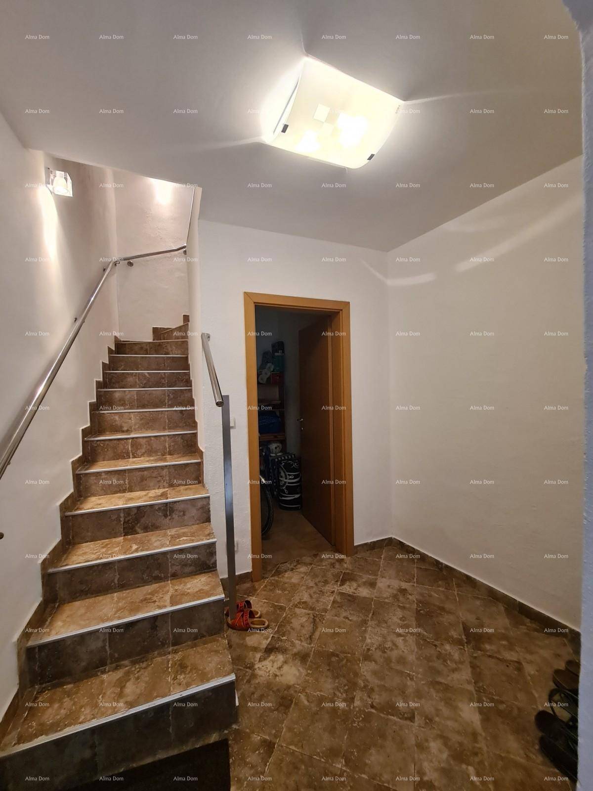 Heller Flur mit gefliestem Boden und Treppe, die zu den oberen Etagen führt.