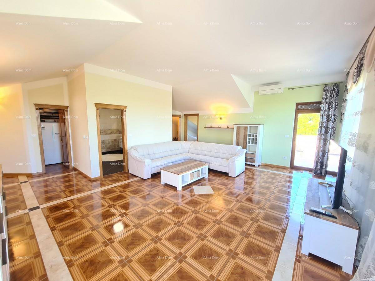 Heller Wohnbereich mit L-förmigem Sofa, gemustertem Fliesenboden und Zugang zu einem Außenbereich.