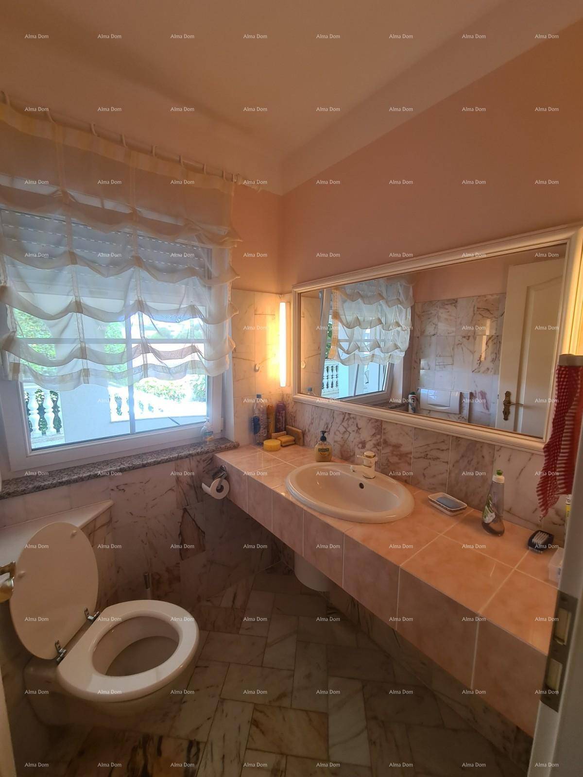 Kleines Badezimmer mit WC, Waschbecken und Fenster, ausgestattet mit Marmorfliesen.