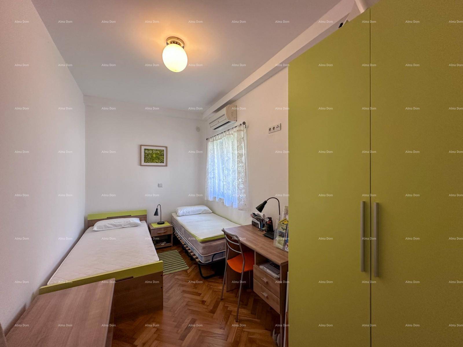 Schlafzimmer mit zwei Einzelbetten, Schreibtisch und einem farbigen Kleiderschrank.