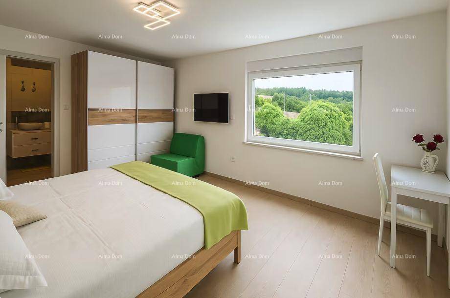 Schlafzimmer mit hellem Holzboden, großem Fenster und Blick auf die grüne Umgebung.