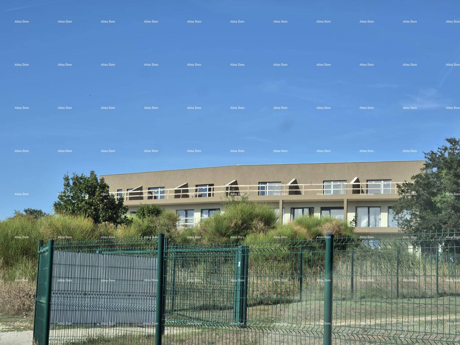 Fassade des modernen Wohngebäudes mit Balkonen und großen Fenstern, umgeben von Natur.
