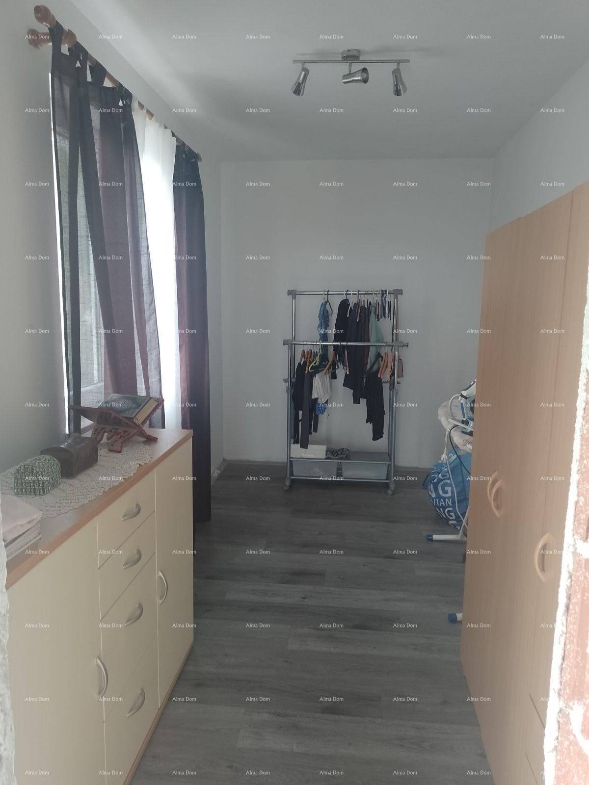 Schlafzimmer oder Ankleidezimmer mit Laminatboden, Kleiderstange und Schrank.