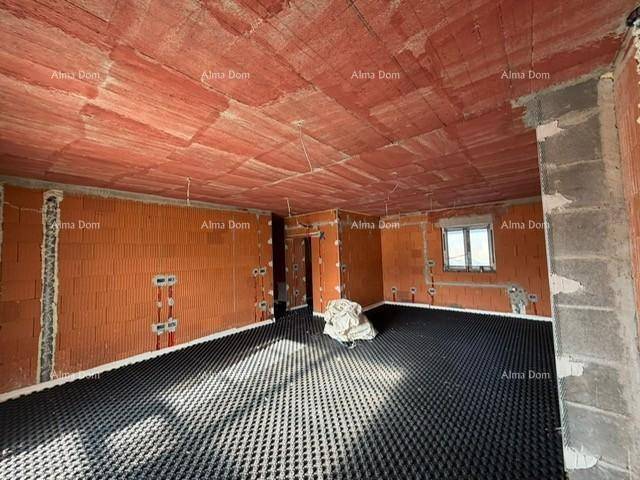 Geräumiger unfertiger Wohnraum mit Ziegelwänden und Fußbodenheizungsvorbereitung für zukünftigen Komfort.