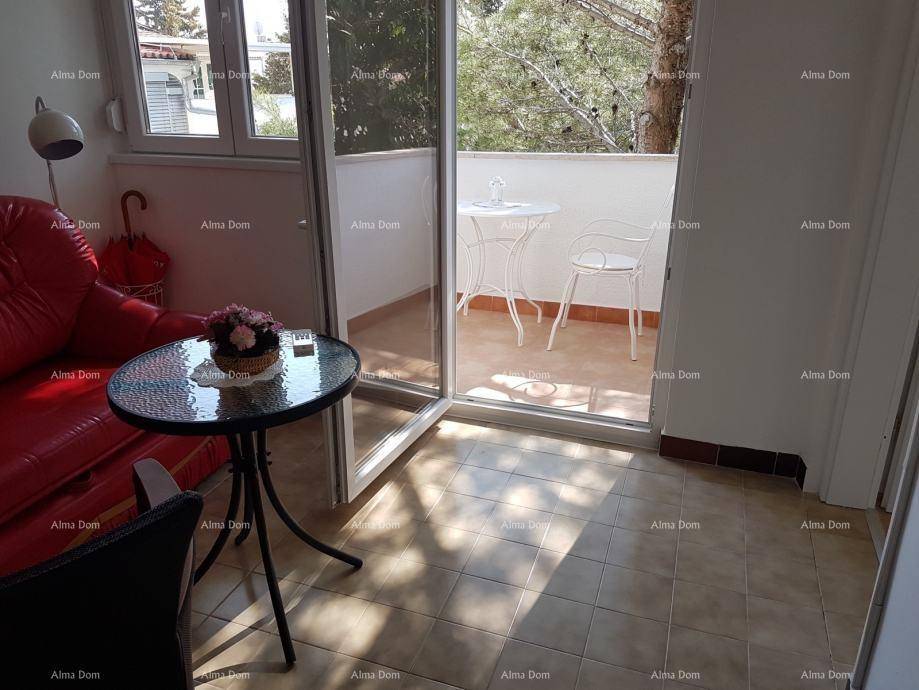 Gemütliches Wohnzimmer mit rotem Sofa, Couchtisch und Zugang zu einem Balkon.