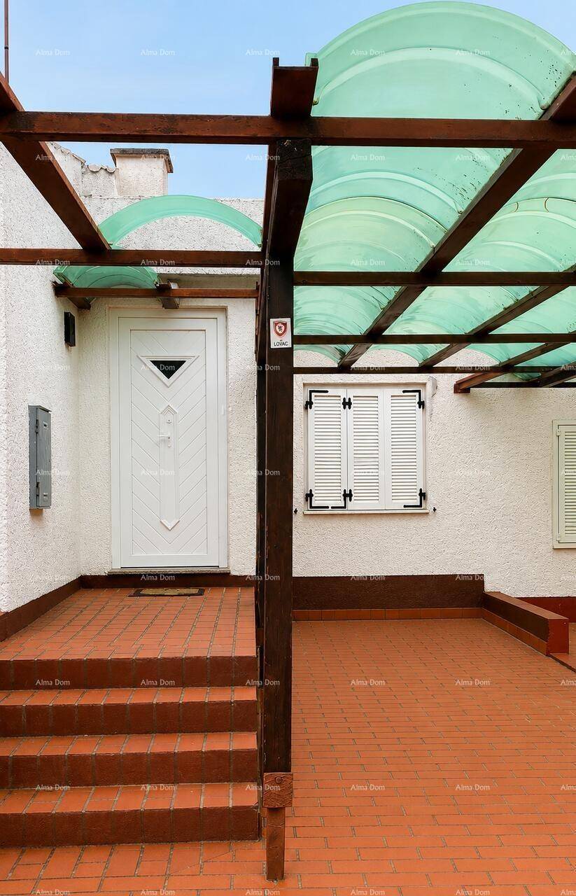 Überdachter Eingangsbereich mit Stufen, Fliesenboden und Fensterläden, bietet Schutz und Stil.
