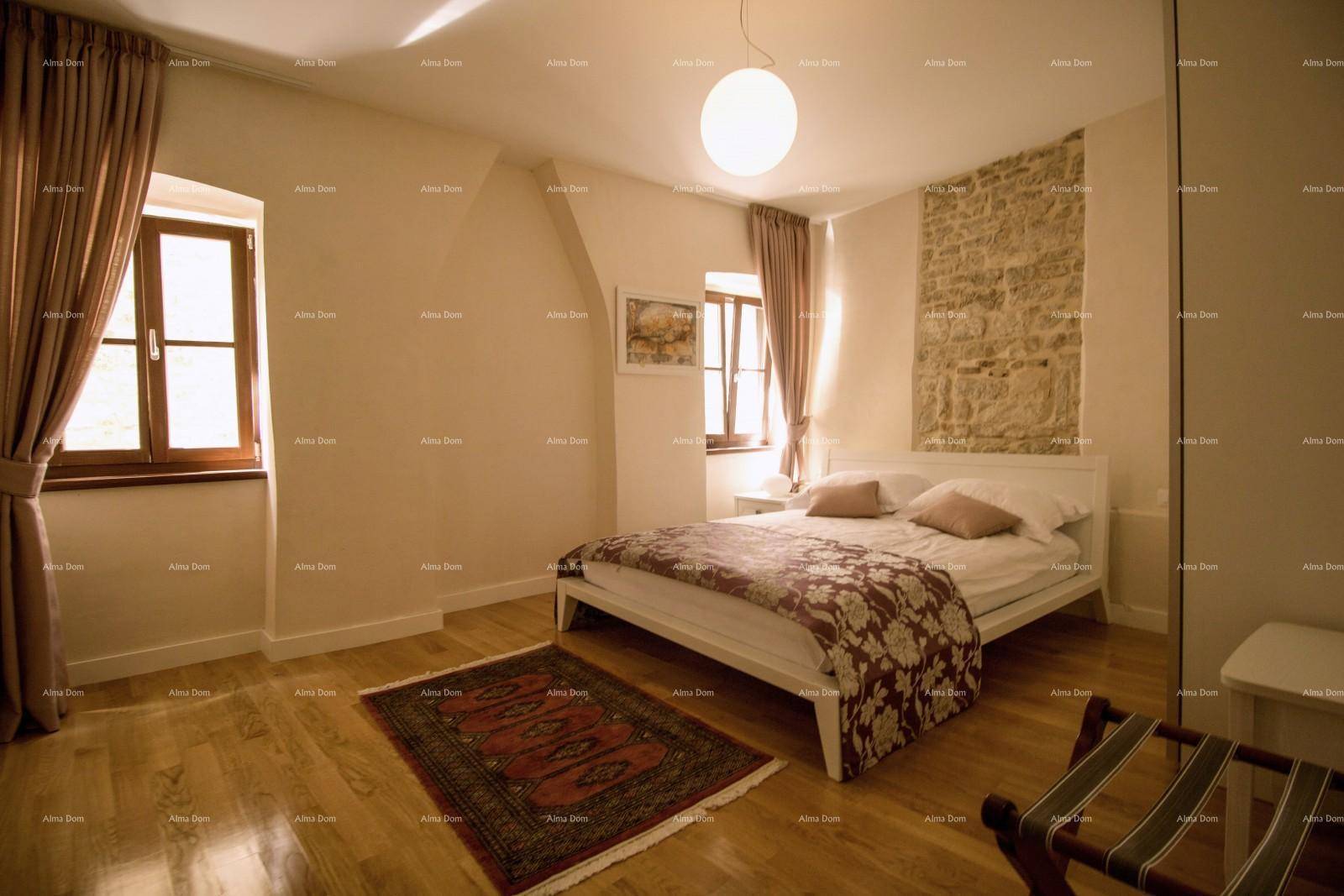 Geräumiges Schlafzimmer mit Holzboden, Doppelbett und zwei Fenstern für viel Tageslicht.
