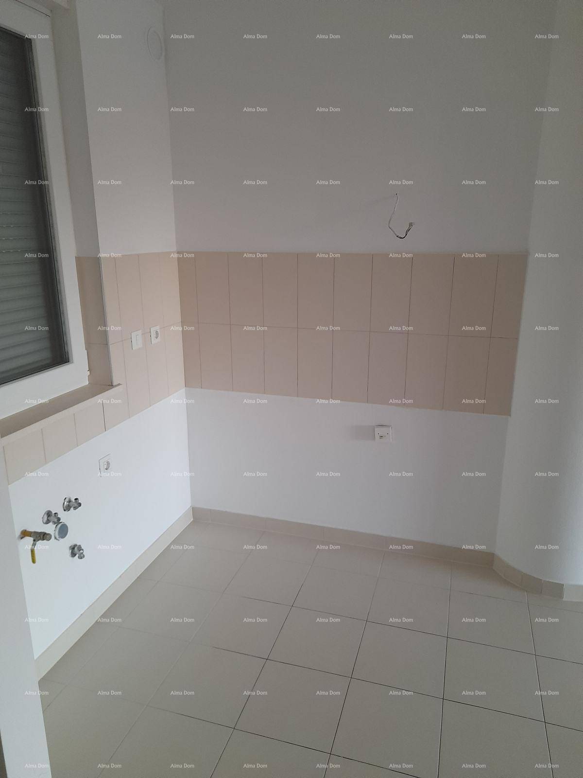 Leere Küche mit Fliesenboden und Wandfliesen, bereit für die Installation einer Einbauküche.