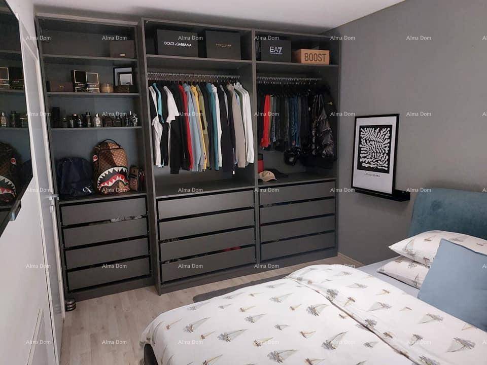 Schlafzimmer mit Bett und einem geräumigen, offenen Schranksystem für Kleidung und persönliche Gegenstände.