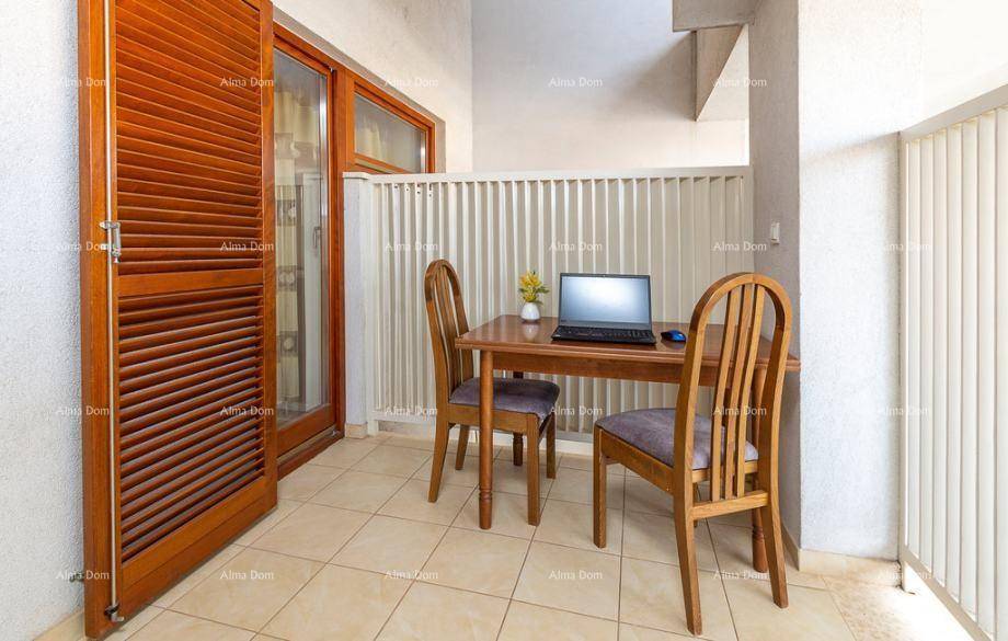 Kleiner Balkon mit Holztisch, Stühlen und Laptop, ideal für Home-Office im Freien.