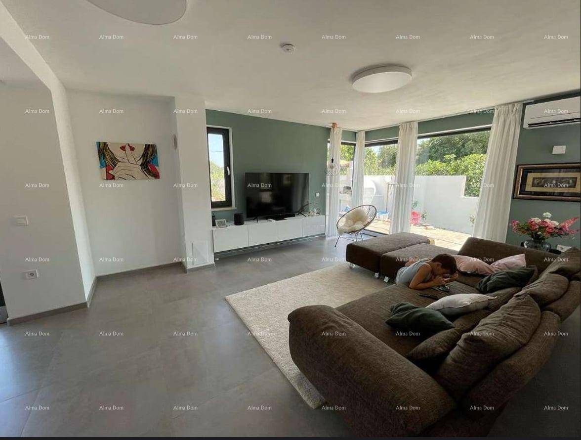Geräumiges Wohnzimmer mit großem Sofa, Fernseher und Zugang zu einer Terrasse.