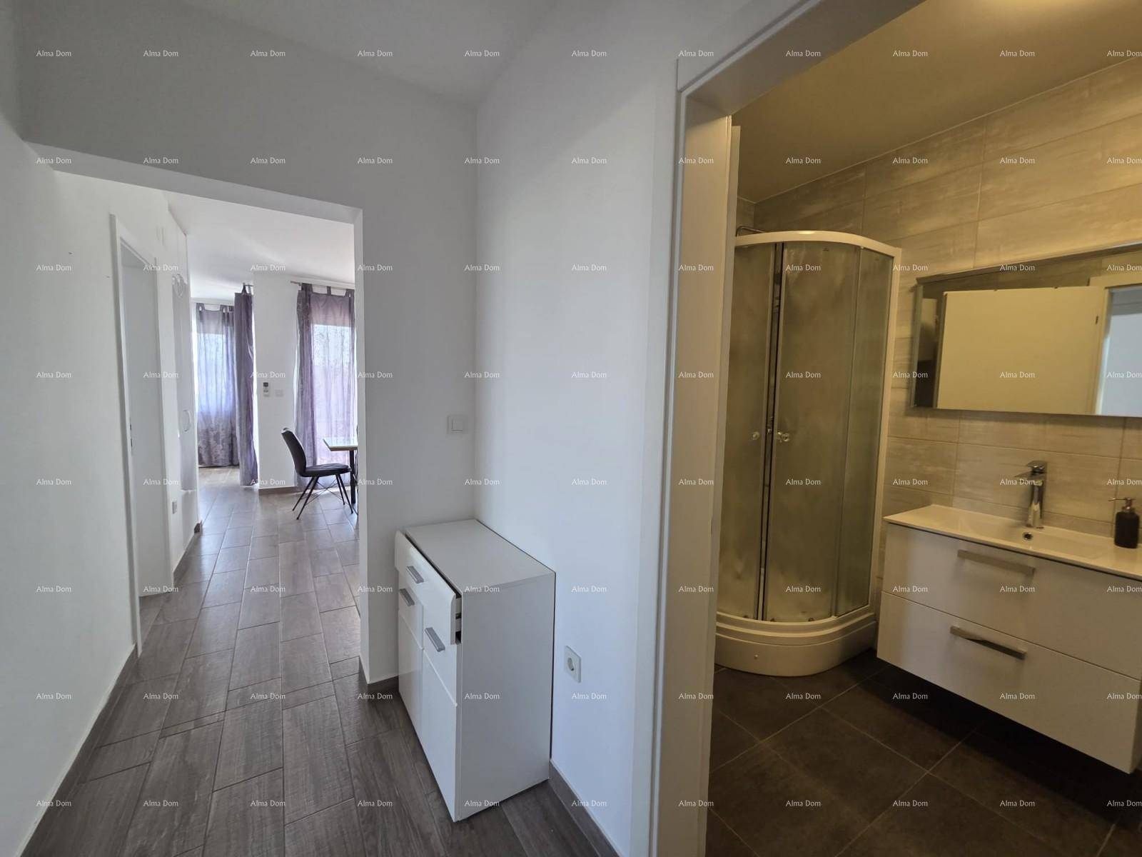 Heller Flur mit Fliesenboden, der zu einem modernen Badezimmer und einem Wohnbereich führt.