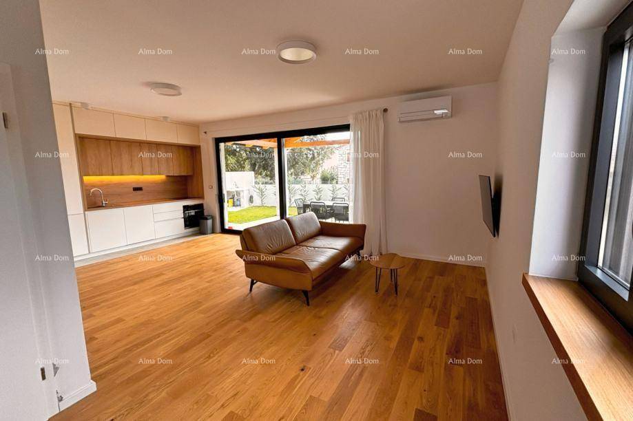 Heller Wohnbereich mit Holzboden, Ledersofa und integrierter Küchenzeile mit Terrassenzugang.