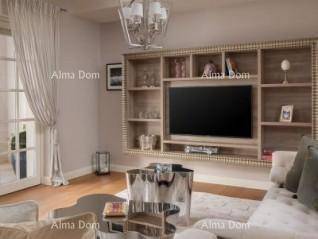 Geräumiges Wohnzimmer mit großem TV-Möbel, bequemen Sofas und einem modernen Couchtisch.