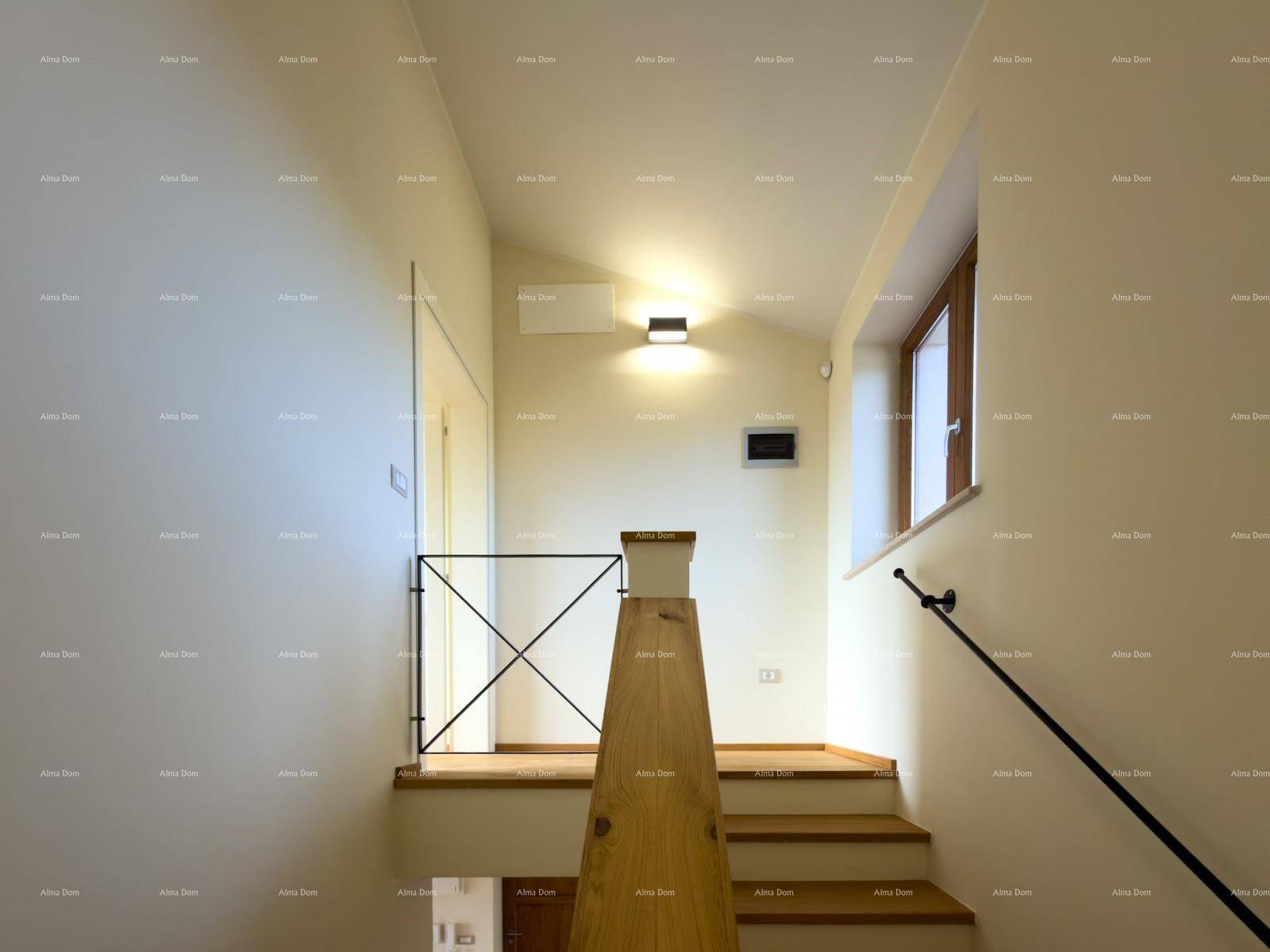 Heller Treppenaufgang mit Holzstufen und schlichtem Geländer, beleuchtet durch ein Fenster.